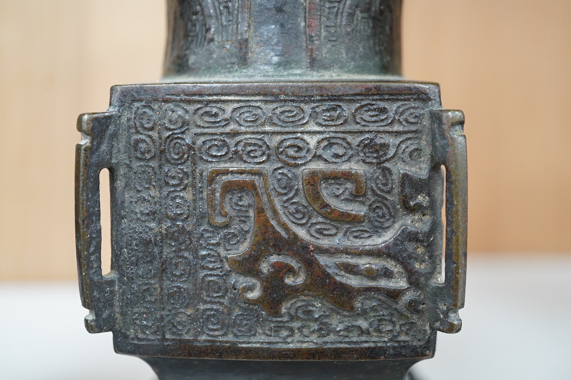 A pair 17th/18th century Chinese archaistic bronze gu vases, and a similar square vase, fanggu, Ming dynasty, tallest 18cm. Condition - poor to fair